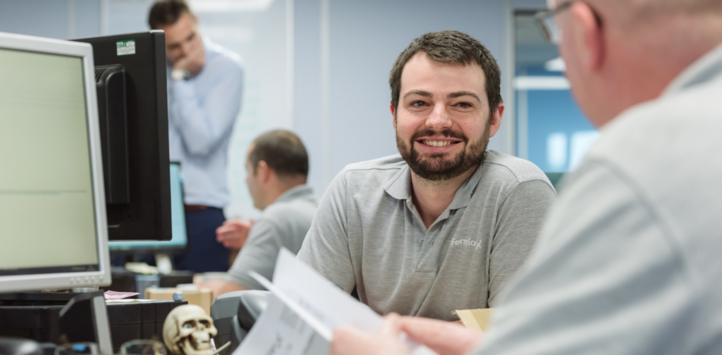 Gary, FermionX team member smiling at his desk